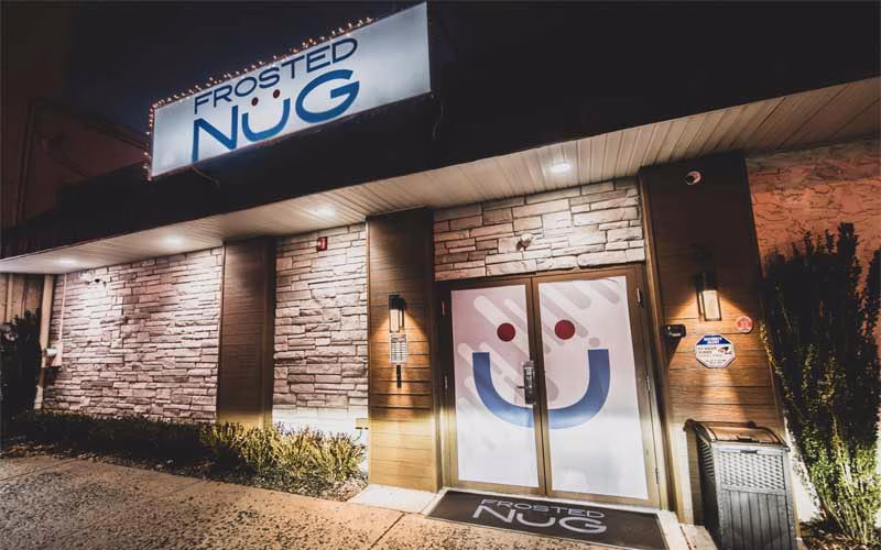Frosted Nug storefront with bright signage and a smiley face on the front door.